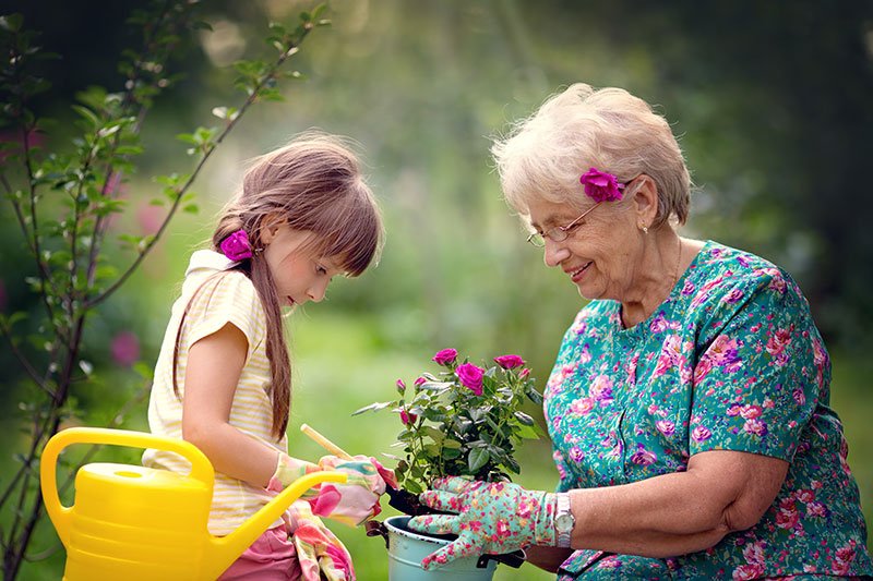 Celebrate a child and an elderly woman work in the garden